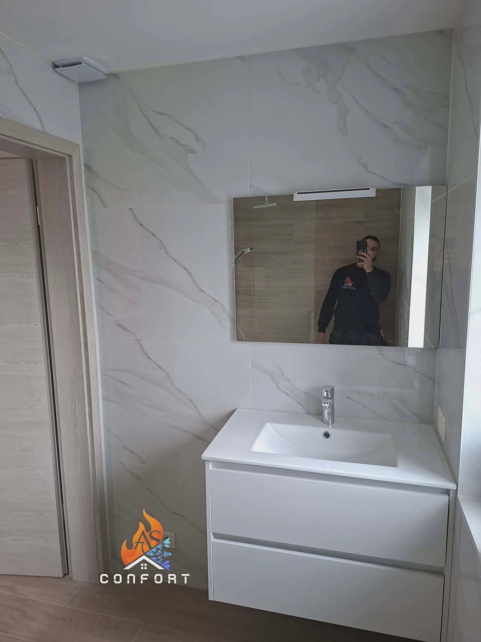 Aleks de AS Confort dans une salle de bain qu’il vient de réaliser